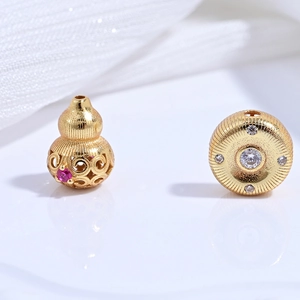 Macro detail of hollow gold-plated s925 gourd bead and round charm with pink zircon