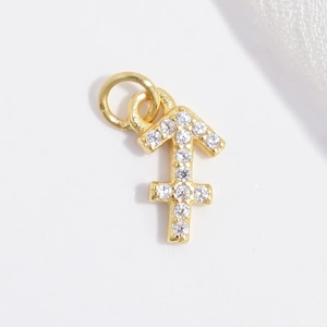 Makro-Detail des goldenen Schütze-Anhängers mit weißem Zirkonia-Mikropavé-Besatz