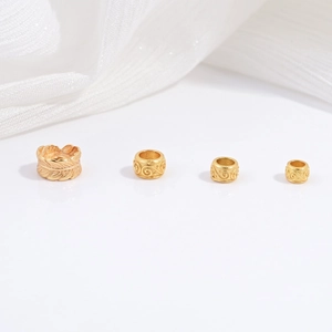 Macro view of gold-plated S925 silver feather and scroll pattern spacer beads for DIY jewelry