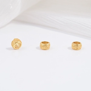 Macro detail of three gold-plated S925 silver beads with vintage relief cloud patterns
