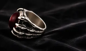 Macro-opname van punk drakenklauw ring met een grote rode edelsteen in zilver metaal