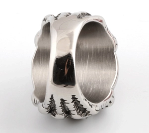 Detailopname van een retro roestvrijstalen ring met een bos- en dennenboommateriaal