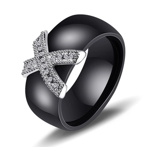 Black ceramic wedding ring featuring a silver X-shape design with micro-pave cubic zirconia