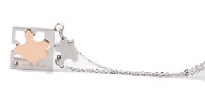 Dettaglio della collana puzzle con testo inciso Only Love e piccolo cristallo lucido
