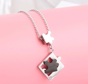 Dettaglio della collana a puzzle con incisione Only Love e un piccolo diamante brillante