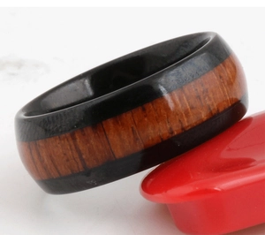 Primo piano dell'anello in acciaio nero lucido da 8 mm con inserto in legno naturale