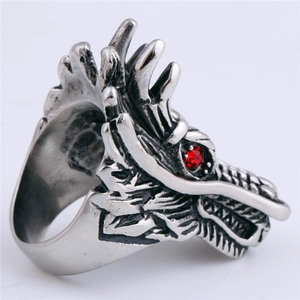 Detailed close-up of a silver dragon head ring with red rhinestone eyes on white background