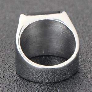 Vue rapprochée d'une bague en acier titane brossé avec pierre noire rectangulaire