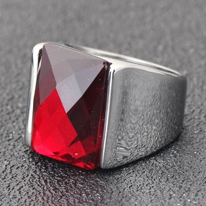 Détail macro d'une bague large pour homme en acier avec un grand gemme rouge rectangulaire