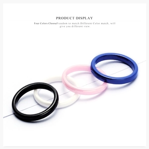 Flat lay of minimalist 3mm ceramic rings in black, white, pink, and blue with glossy finish