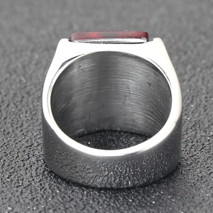 Détail d'une large bague pour homme en acier titane avec un rubis rectangulaire serti