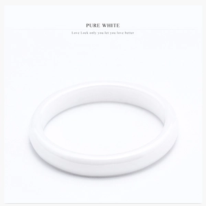 Close-up of a pure white ceramic ring with a smooth polished finish and minimalist design