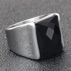 Détails macro d'une bague large en acier pour homme avec pierre onyx noire à facettes