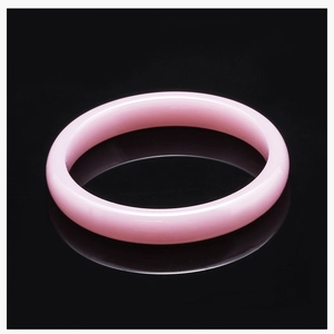 Detailed macro view of a polished pink ceramic ring with a smooth rounded surface