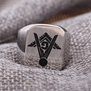 Anillo de sello cuadrado en acero pulido con logo masónico negro sobre tela gris