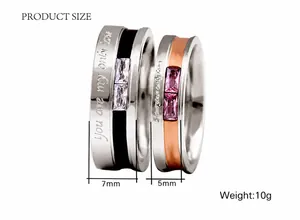 Detail of 7mm black and 5mm rose gold rings with engraved love message and zircon