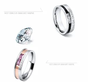 Close-up of engraved stainless steel couple rings with zircon inlay and romantic quote