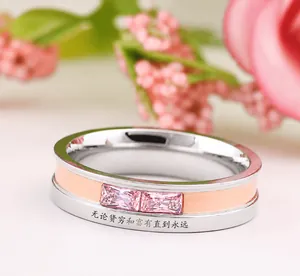 Macro shot of two-tone ring with pink gemstones and I am your only love engraving