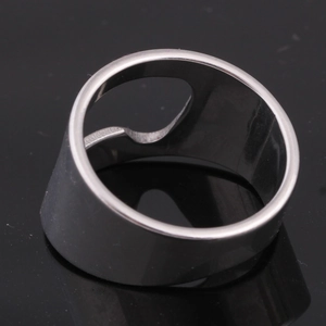 Makrodetail eines silbernen Flaschenöffner-Rings aus Edelstahl auf schwarzer Reflexfläche