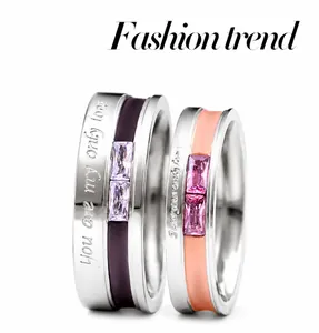 Close-up of titanium steel couple rings with cubic zirconia and love engravings
