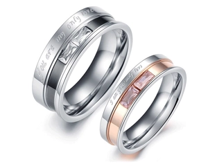 Close-up of engraved couple rings with cubic zirconia and silver-rose gold plating