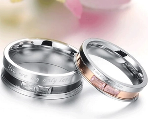 Macro detail of couple rings with engraved love quotes and inlaid zircon stones