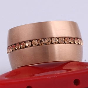 Macro-opname van 14mm roségoud geborstelde ring met ingelegde amberkleurige stenen