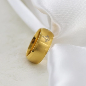 Dettaglio dell'anello da 8mm in acciaio dorato spazzolato con incisione logo massonico