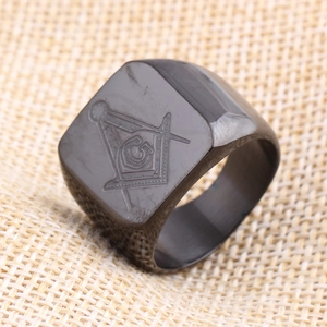 Gros plan sur bague en acier noir avec logo maçonnique gravé de l'équerre et du compas