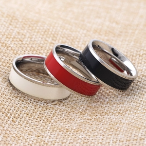 Close-up of 7mm stainless steel rings in ivory, red, and black enamel finishes