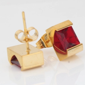 Detail of square gold earrings with red cubic zirconia and butterfly backing