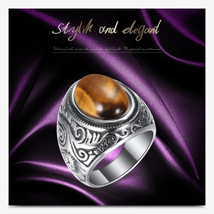 Detailed macro shot of vintage stainless steel ring with oval tiger eye stone and vine relief