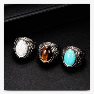 Detailed close-up of three vintage stainless steel rings with turquoise and marble stones
