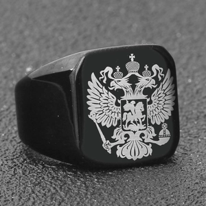 Detail showing laser-engraved double-headed eagle emblem on a black signet ring