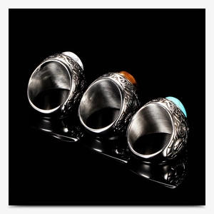 Macro detail of retro stainless steel rings with turquoise and tiger eye stone inlays
