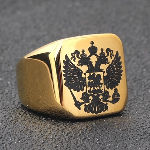 Macro detail of golden stainless steel signet ring with black double-headed eagle emblem