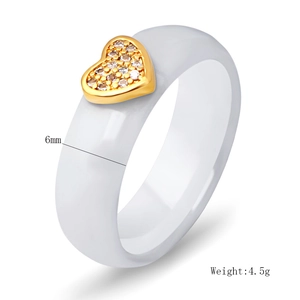 Detail view of 6mm white ceramic ring featuring a gold heart with pavé cubic zirconia