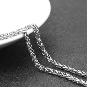 Macro shot of silver wheat chain necklace featuring a vintage metallic texture and links