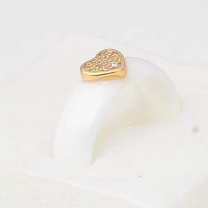 White ceramic ring featuring a gold heart inset with sparkling cubic zirconia stones