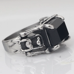 Macro detail of gothic claw ring featuring human torso carving and black square stone