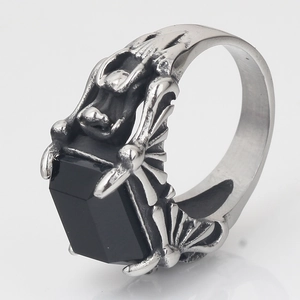 Macro detail of gothic ring featuring a black gemstone held by skeletal claw prongs