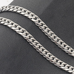 Close-up detail showing the polished silver 4mm stainless steel Cuban link chain texture