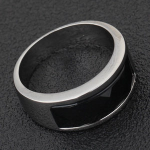 Macro view of stainless steel ring with black rectangular inlay and brushed metal finish