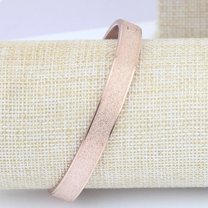 Detailed macro shot of the frosted rose gold texture on an 8mm stainless steel bangle