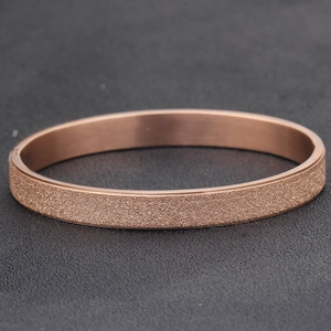 Close-up of frosted rose gold stainless steel bangle with a starry textured finish