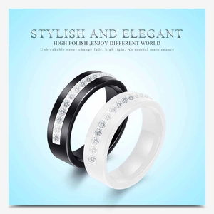 Macro view of high polish black and white ceramic rings with single row sparkling stones