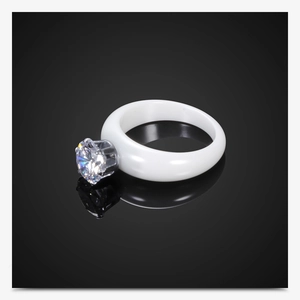 Primer plano de un anillo de cerámica blanca con una gran circonita cúbica y engaste de 6 garras