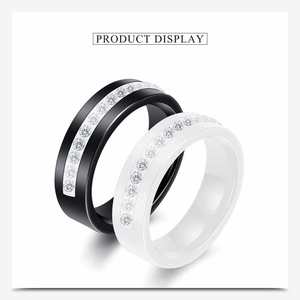 Close-up of black and white ceramic rings with single row of cubic zirconia stones