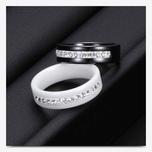 Close-up of black and white ceramic rings featuring a single row of sparkling crystals
