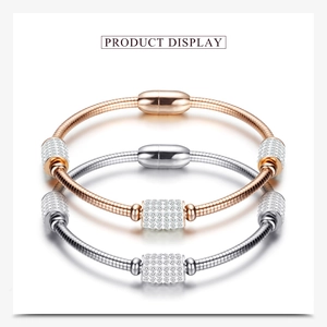 Détail de bracelets chaîne serpent en or rose et argent avec charmes en zircone